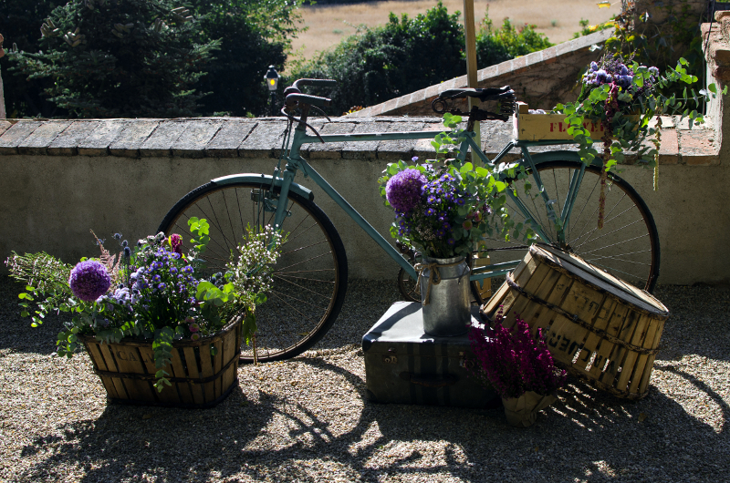 Decoración de boda con bicicleta, carro y cajas con flores