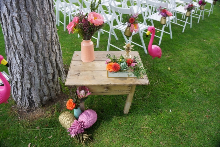 Decoración de una boda tropical con crasas, peonías corales, tulipanes y rosas