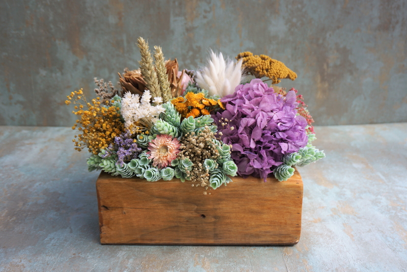 Centro de flores en caja de madera con base de piña "Mamá a la fuerza"