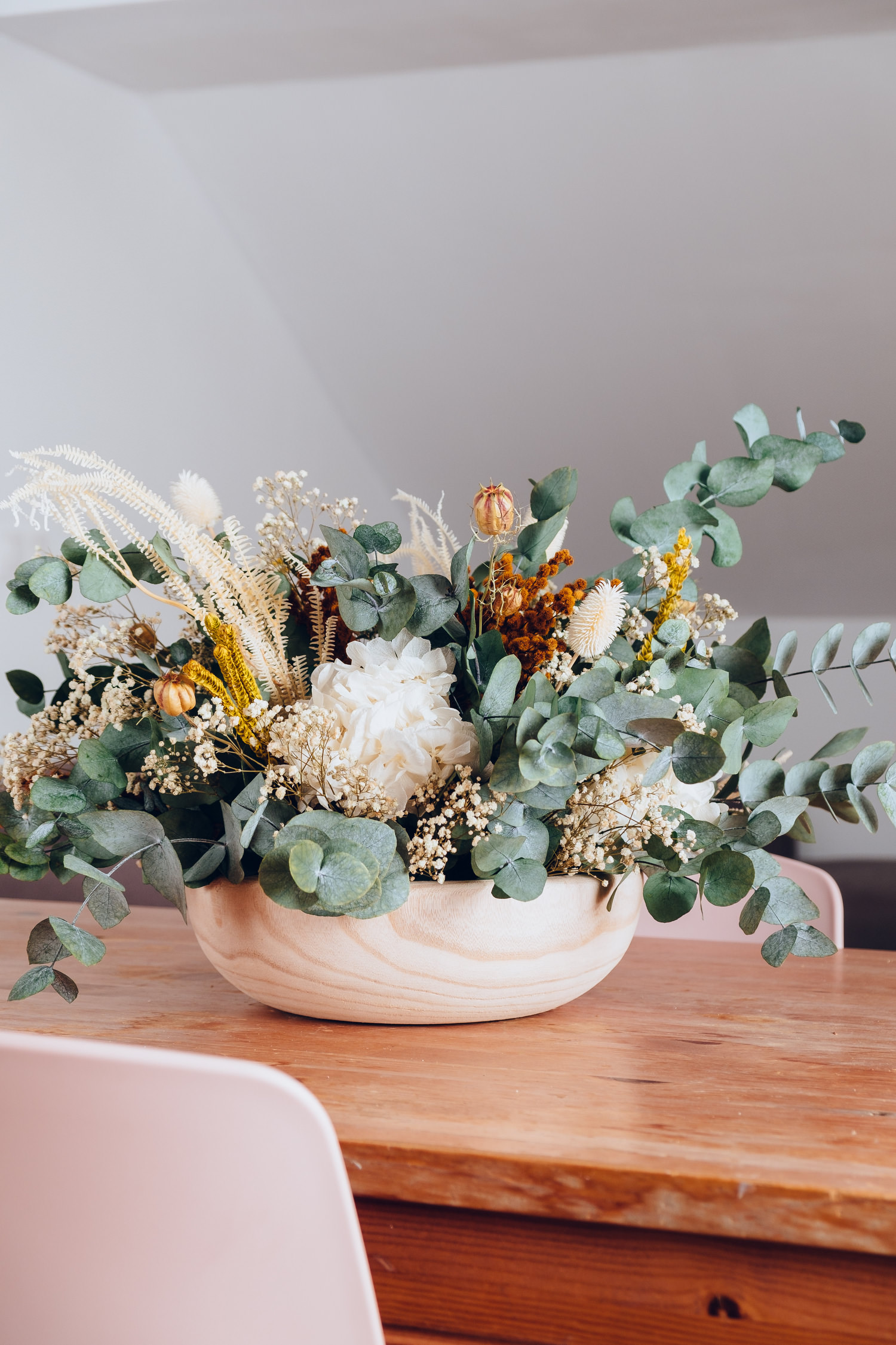 Centro de madera redondo de flores preservadas en tonos neutros