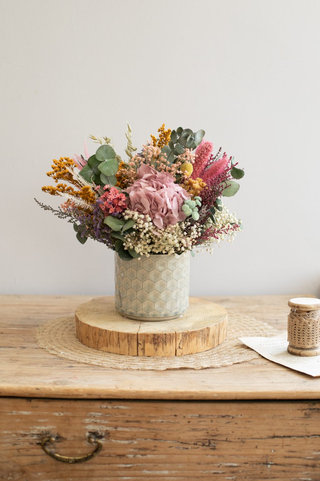 Jarrón de cerámica con hortensias y flores preservadas