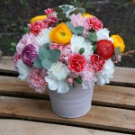 Centro de flores naturales con ranúnculos, claveles, eucalipto, ...